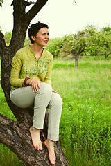 Image showing girl sitting on a tree