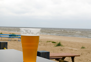 Image showing full beer stein mug stand pub table near sea beach 