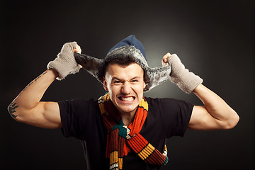 Image showing  man pulling on his fur winter hat