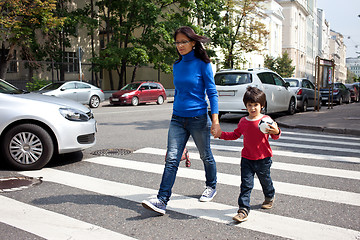 Image showing woman with a child going on a pedestrian crossing in the city 