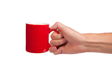 Image showing Male hand is holding a red cup