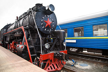 Image showing Old steam train is leaving a station