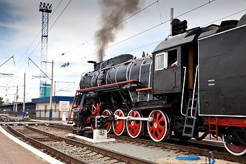 Image showing Old steam train is leaving a station