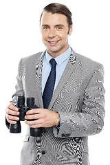 Image showing Smiling male consultant holding binoculars