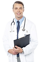 Image showing Smiling professional physician carrying clipboard