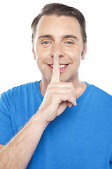 Image showing Smiling young man gesturing silence