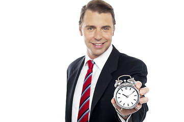 Image showing Smiling young consultant showing alarm clock