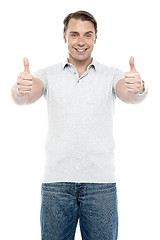 Image showing Good looking cheerful man showing double thumbs up