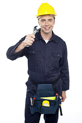 Image showing Smiling repairman holding out screwdriver