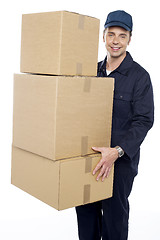 Image showing Working man delivering stack of cardboard boxes