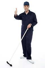 Image showing Cleaning guy holding broom and showing thumbs up