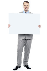 Image showing Successful business executive holding blank ad board