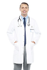 Image showing Young doctor posing with hands in his overcoat