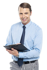 Image showing Smiling male secretary holding a clipboard