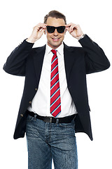 Image showing Young business achiever holding shades in style