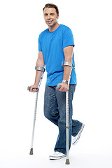 Image showing Young man with crutches trying to walk