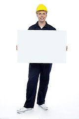 Image showing Repairman holding blank billboard, full length portrait