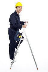 Image showing Industrial employee stepping up the ladder