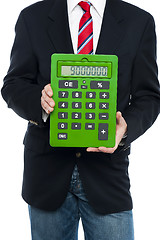 Image showing Cropped image of business guy holding calculator