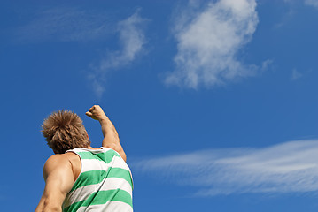 Image showing The winner. Sporty guy with his arm raised in joy.