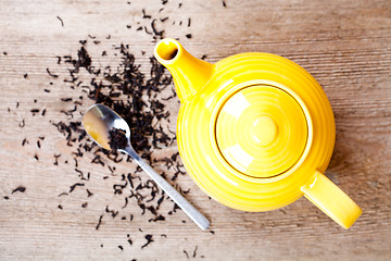 Image showing yellow teapot with spoon and tea 