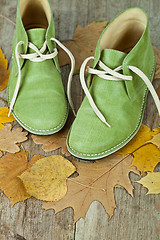 Image showing green leather boots and yellow leaves