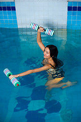 Image showing Attractive girl trains in aqua aerobics