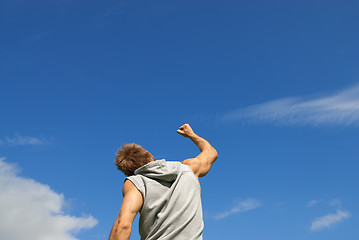 Image showing Sporty young man with his arm raised in joy