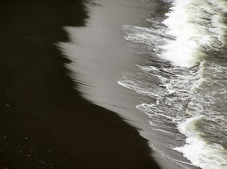 Image showing waves breaking onto black beach of Iceland