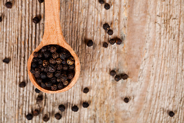 Image showing black peper in wooden spoon 