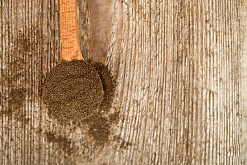 Image showing ground black pepper in wooden spoon