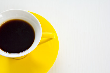 Image showing Black coffee in yellow cup and saucer