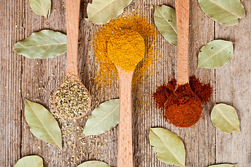 Image showing pices in wooden spoons and bay leaves