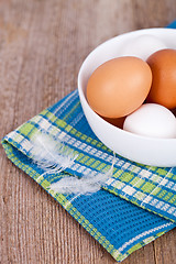 Image showing eggs in a bowl, towel and feathers