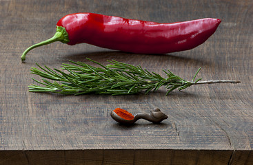 Image showing Fresh red pepper, sprig of rosemary, wooden measuring spoon of g