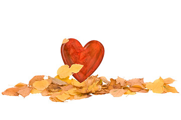 Image showing heart in the pile of autumn yellow leaves