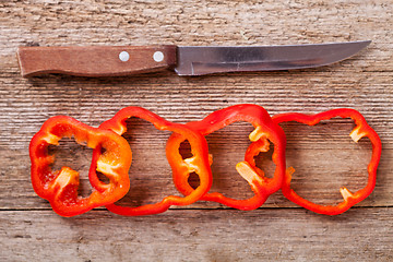 Image showing sliced red bell peppers and old knife