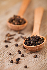 Image showing black pepper and cloves in wooden spoons 