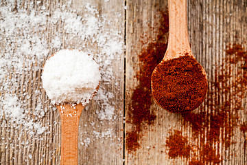 Image showing ground red pepper and cooking salt in wooden spoons 