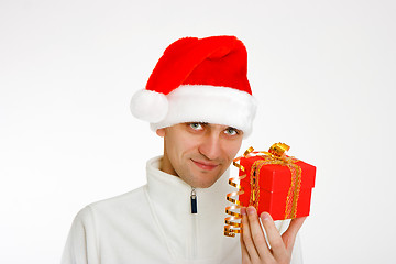 Image showing young man in a Santa hat holding gift