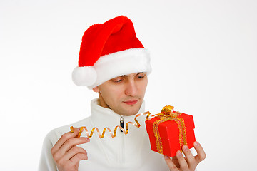 Image showing young man in a Santa hat holding gift