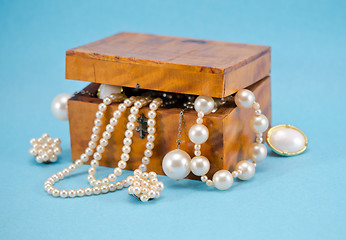 Image showing Pearl jewelry defocus in retro wooden box on blue 