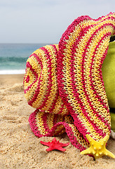 Image showing Green beach bag, pink straw hat and funny sea stars