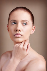 Image showing Portrait of young beautiful woman with clear make-up over brown background 