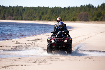 Image showing two men riding all-terrain vehicle