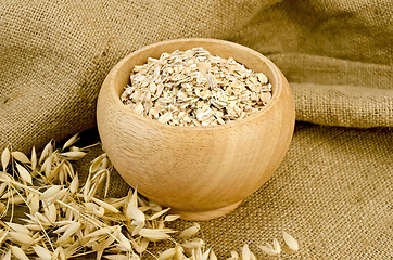 Image showing Oat flakes in a bowl on sacking