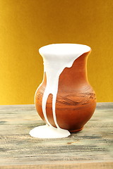 Image showing Ceramic jug overflowing cream.