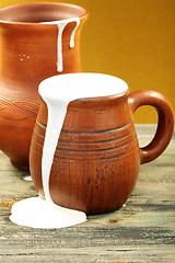 Image showing Ceramic mug with cream and clay jug.