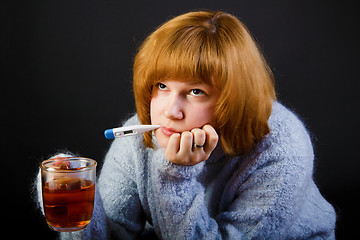 Image showing sick girl with tea and a thermometer