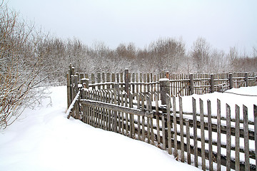 Image showing old wooden fence on winter snow